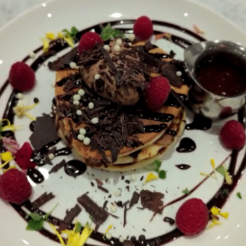 Chocolate and Raspberry Triple Stack Pancake with chocolate drizzle & rasperry coulis available for pancake day 2023