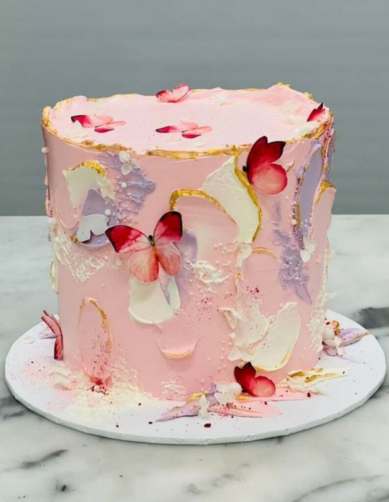 Custom decorated cake available at Brunetti Classico Carlton. Pink textured buttercream and butterfly motifs. Little girls birthday party cake, gender reveal cake, baby shower cake, pink cake, 1st birthday cake