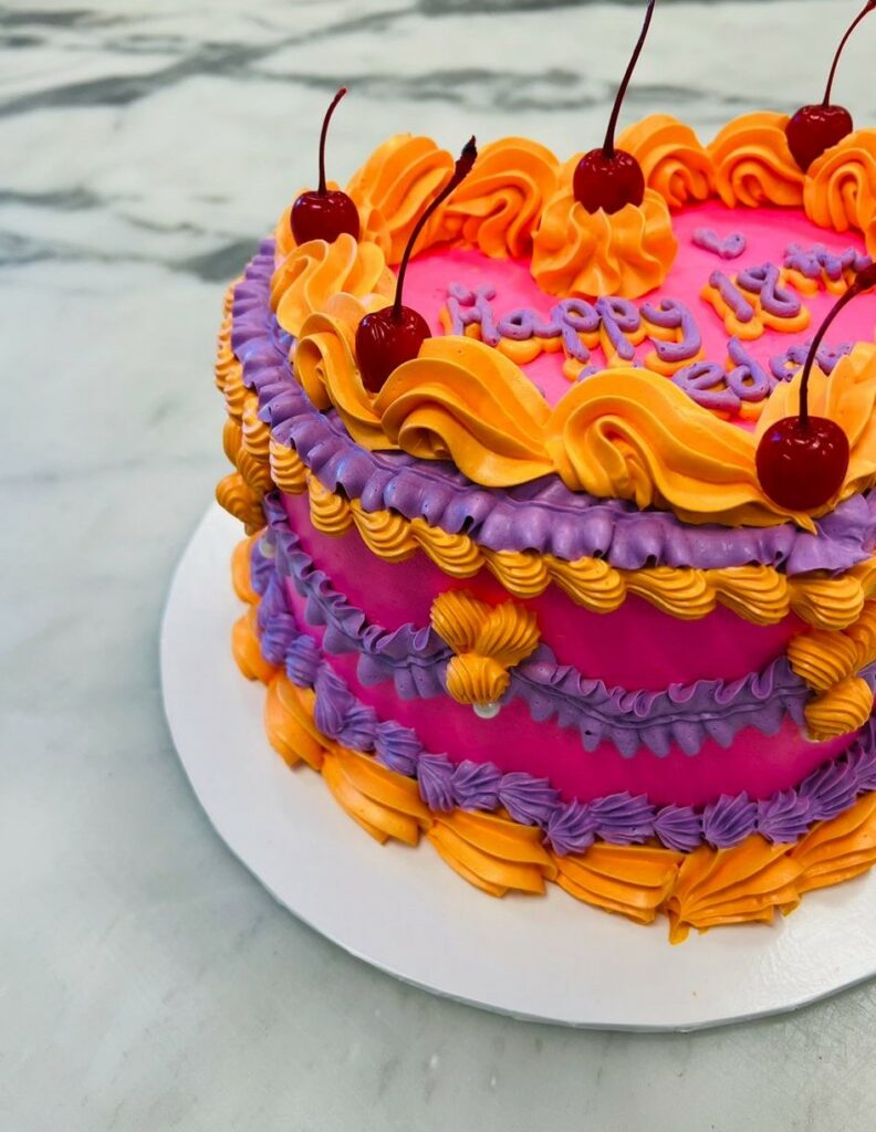 Custom decorated cake available at Brunetti Classico Carlton. Heart shape, retro vintage style buttercream decorated cake. 18th birthday party cake with cherries and buttercream. Birthday party cake, heart shaped cake