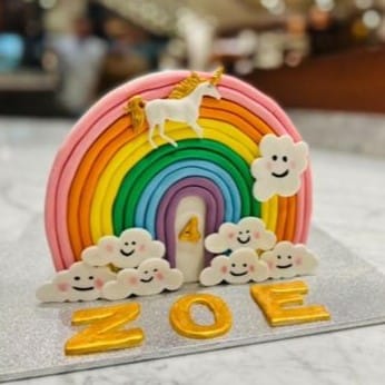 Custom decorated cake available at Brunetti Classico Carlton. Rainbow arch cake, cake top forward cake. Decorated with rainbow fondant, cloud and unicorn fondant shapes.